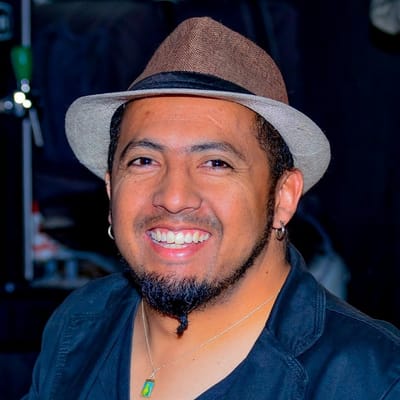 Álvaro sorrindo para a câmera, de chapéu, no Blackout Pub.