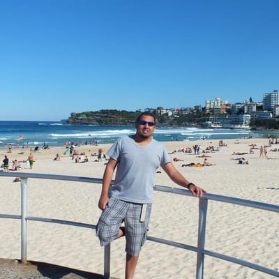 Álvaro na areia de Bondi Beach, com o mar atrás.